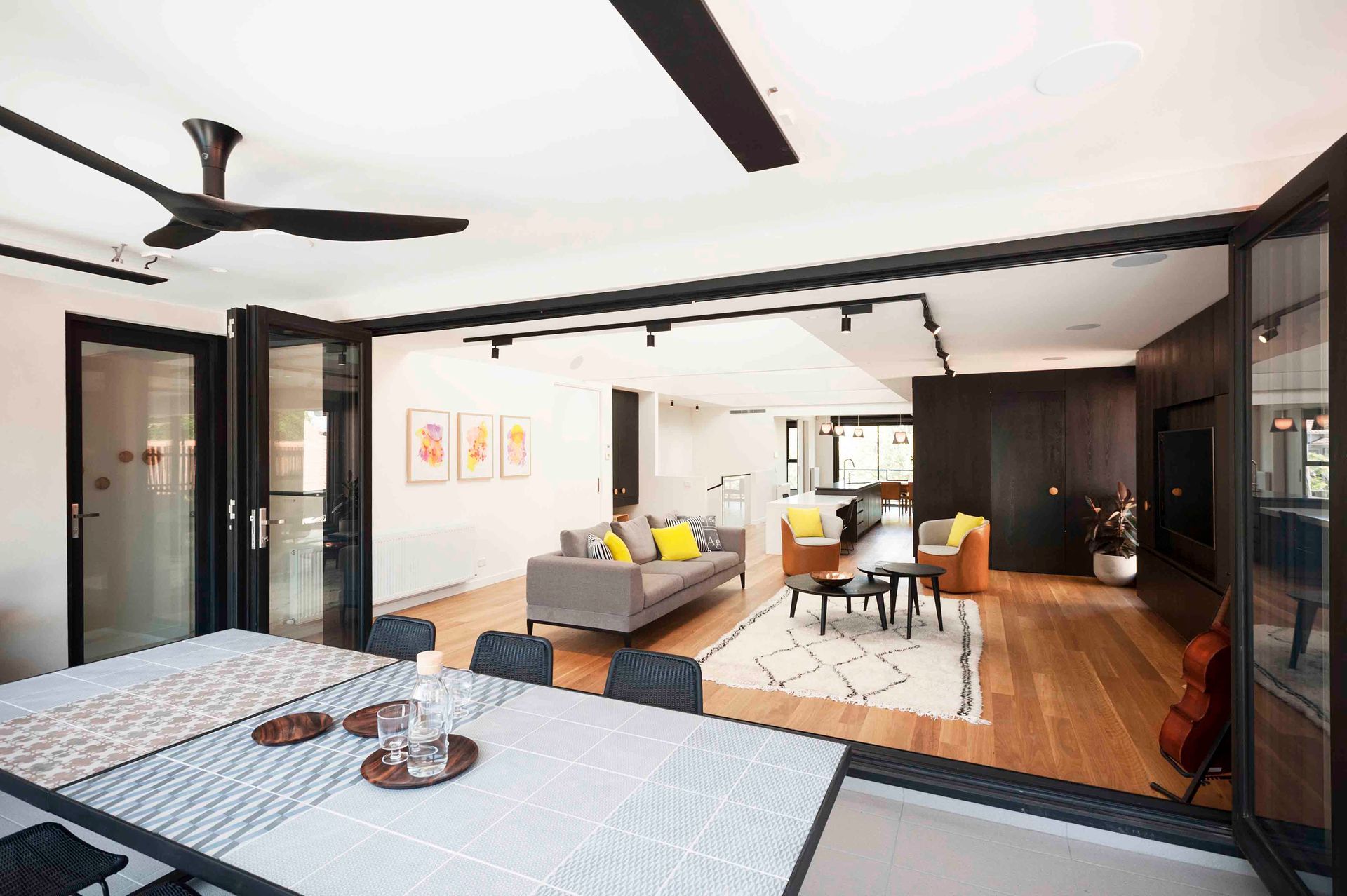A living room with a table and chairs and a ceiling fan.