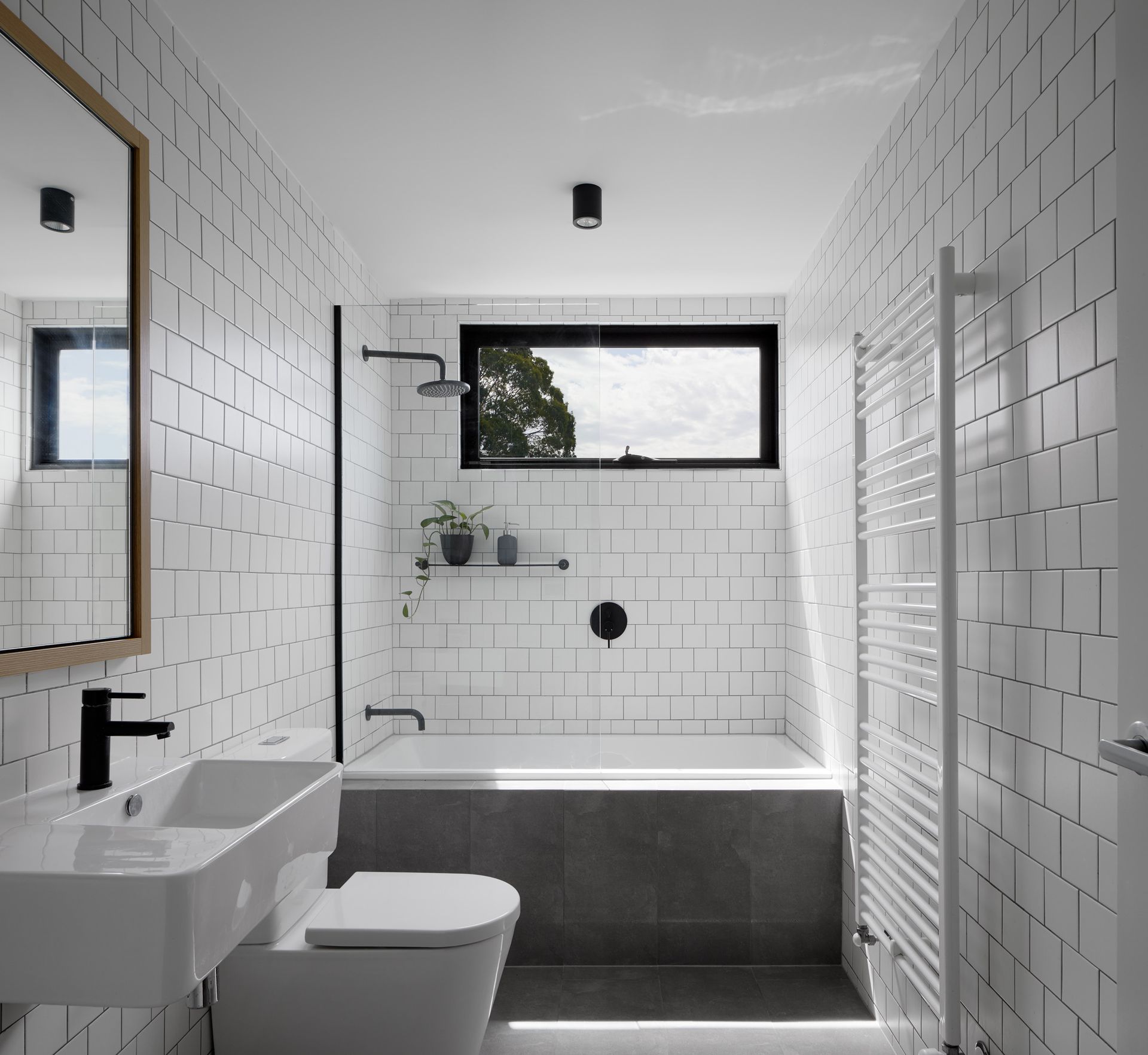 A bathroom with a toilet , sink , tub and mirror