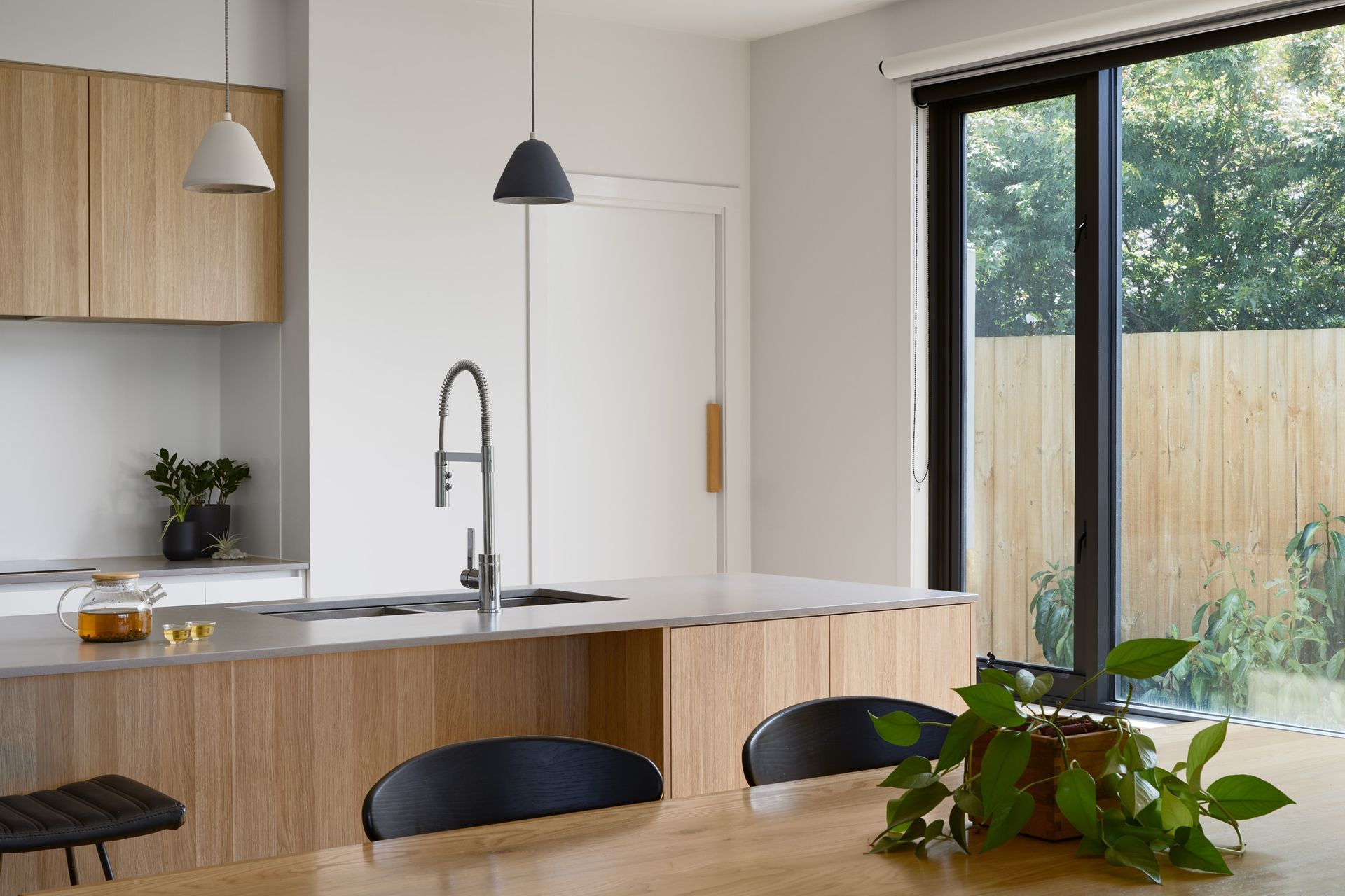 A kitchen with a table and chairs and a sliding glass door.