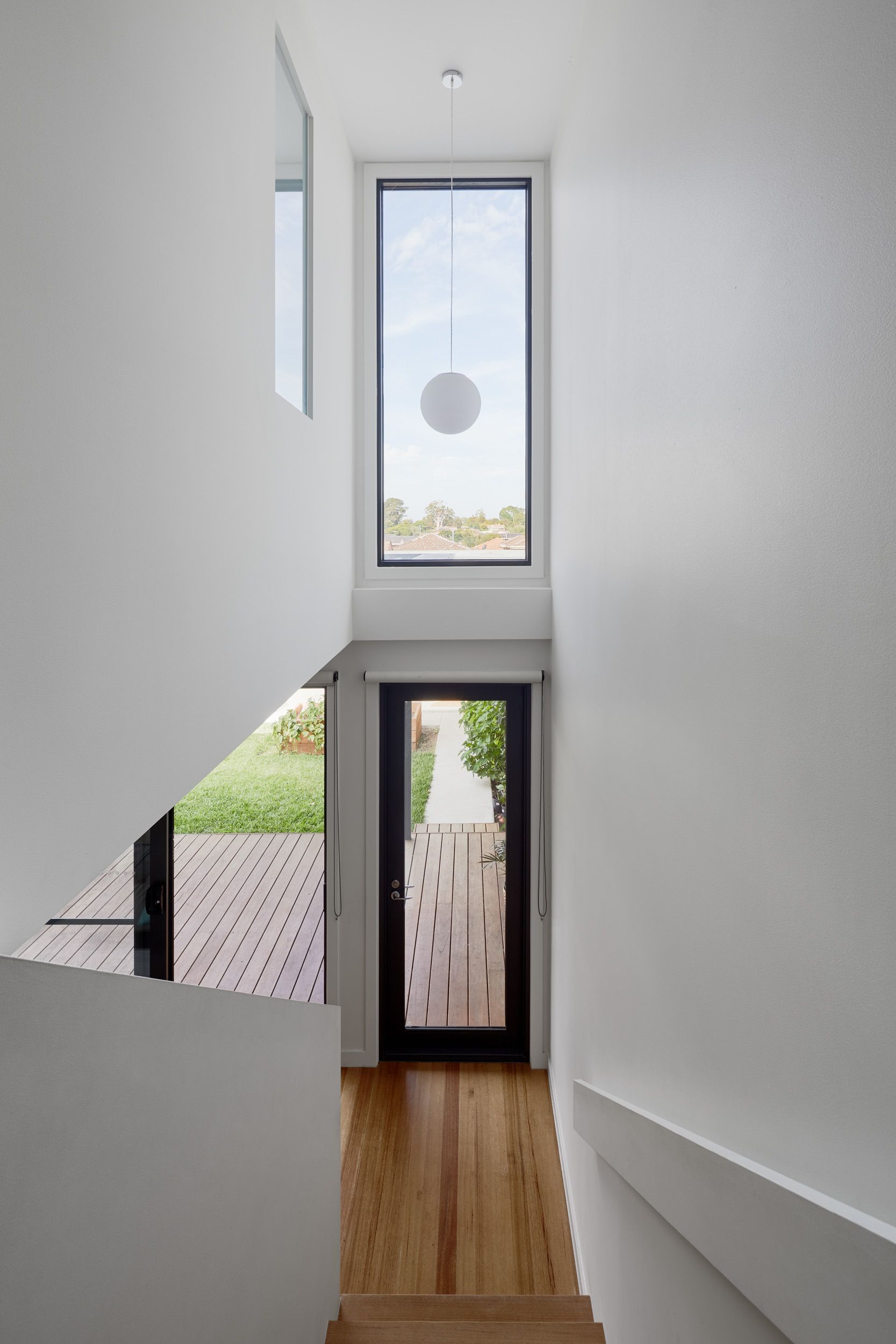 A hallway with stairs and a large window