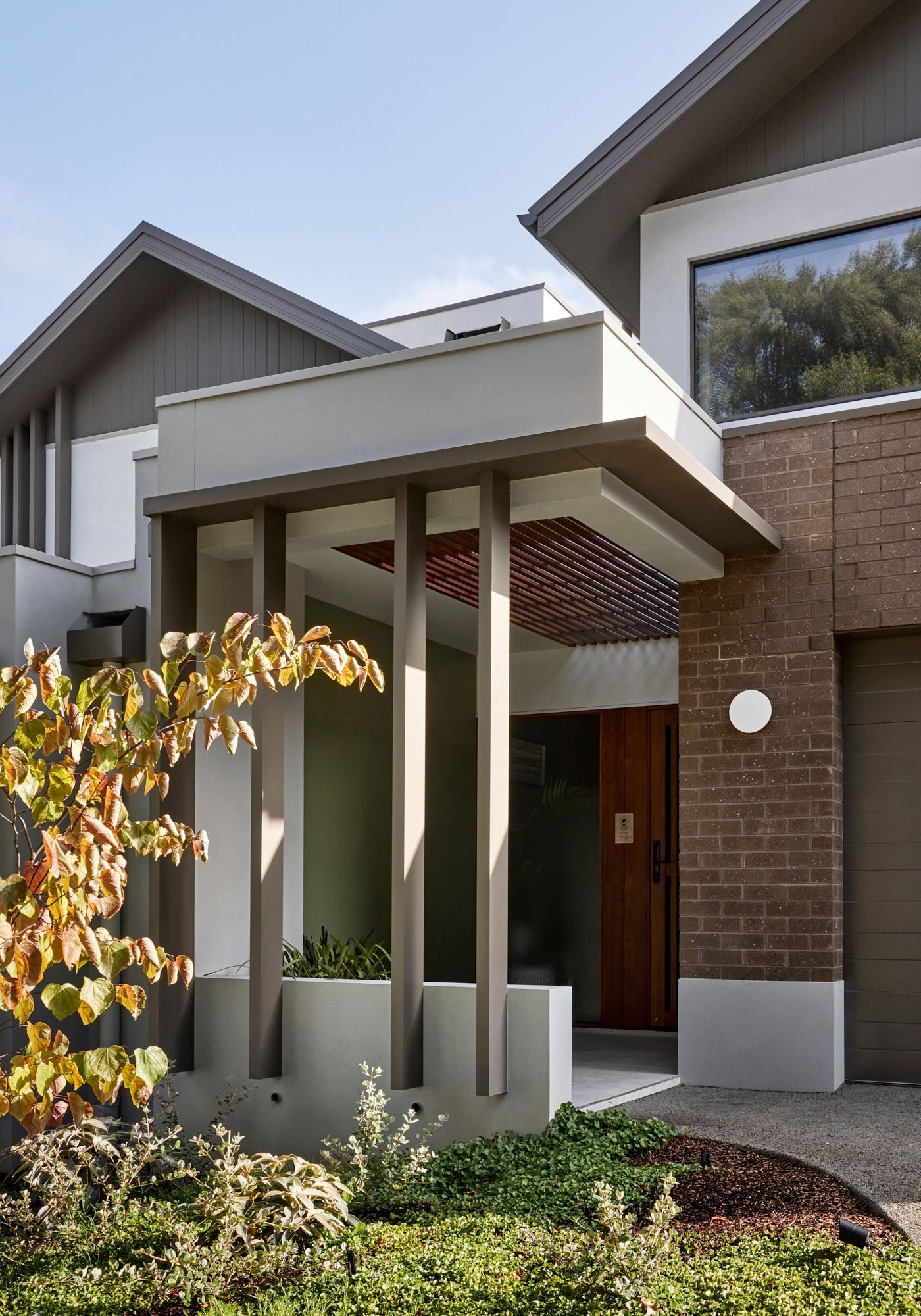 A modern house with a porch and a brick wall