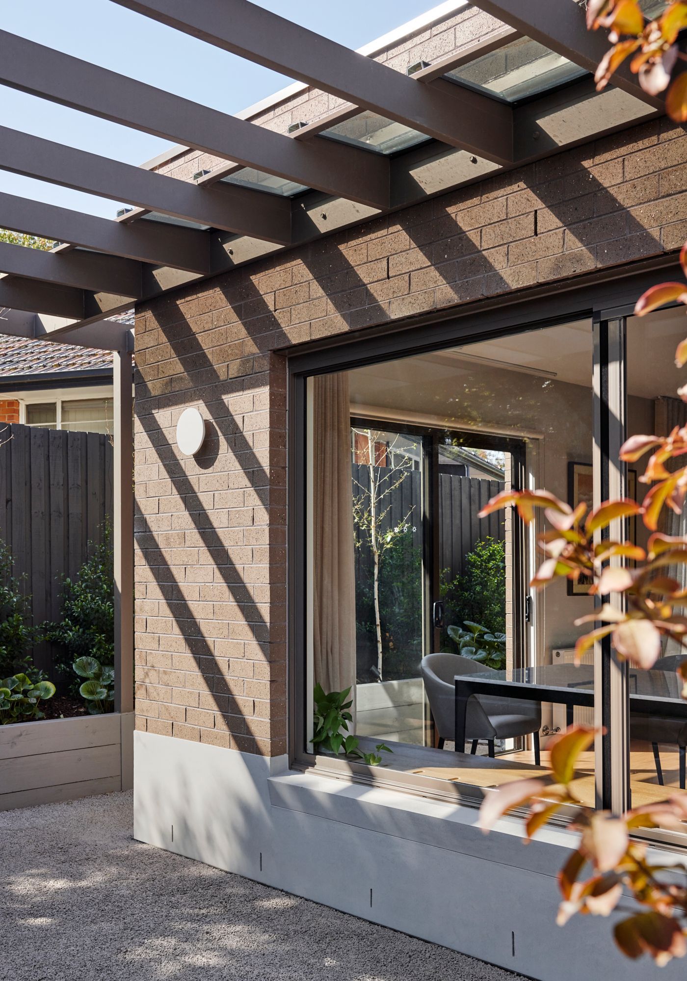 A house with a sliding glass door and a pergola.