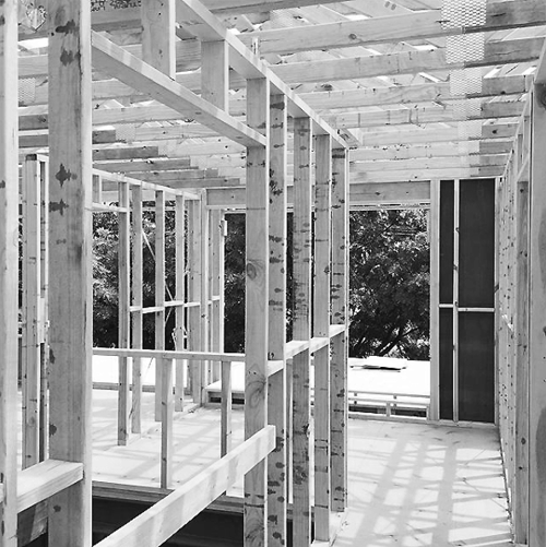 A black and white photo of a house under construction