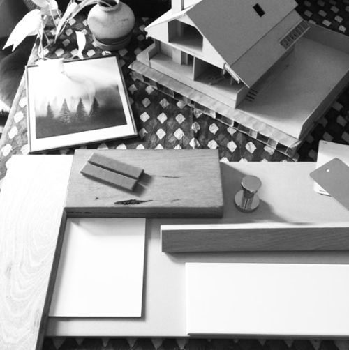 A black and white photo of a model house on a table
