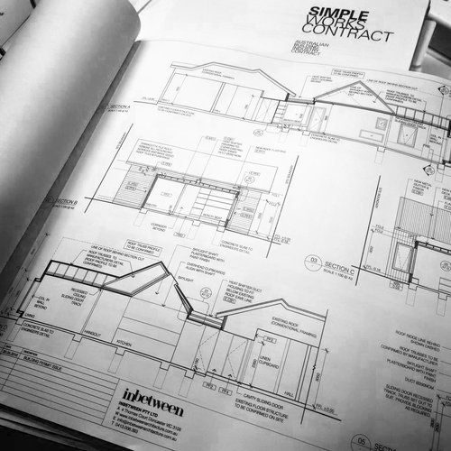 A black and white drawing of a house is on a table.