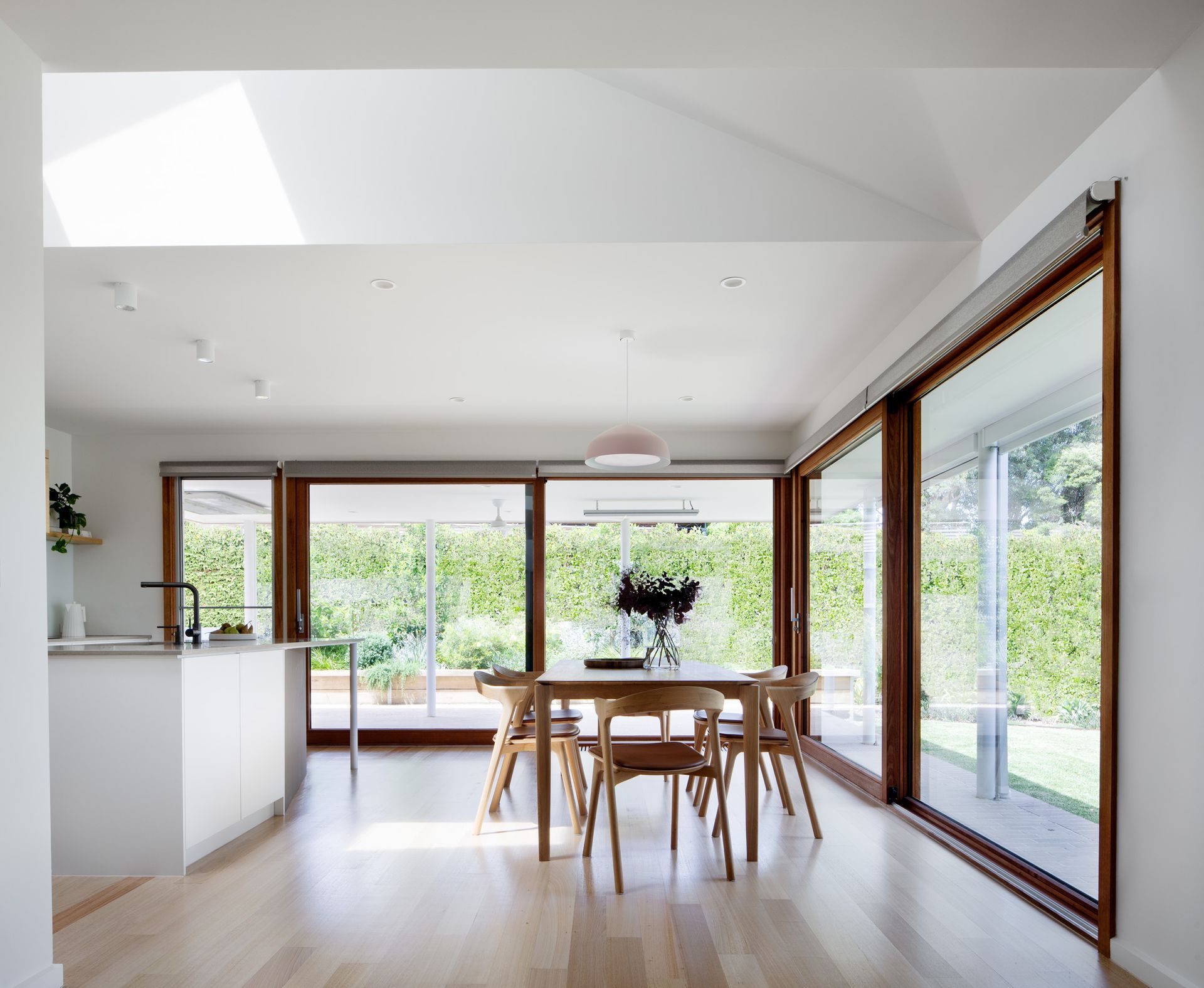 A dining room with a table and chairs and sliding glass doors