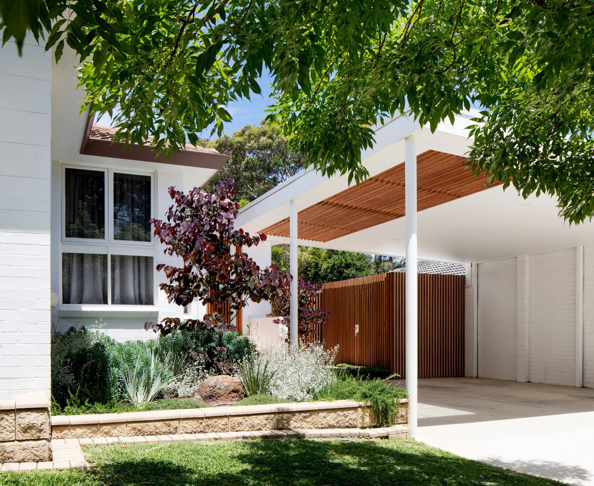 A white house with a carport underneath it