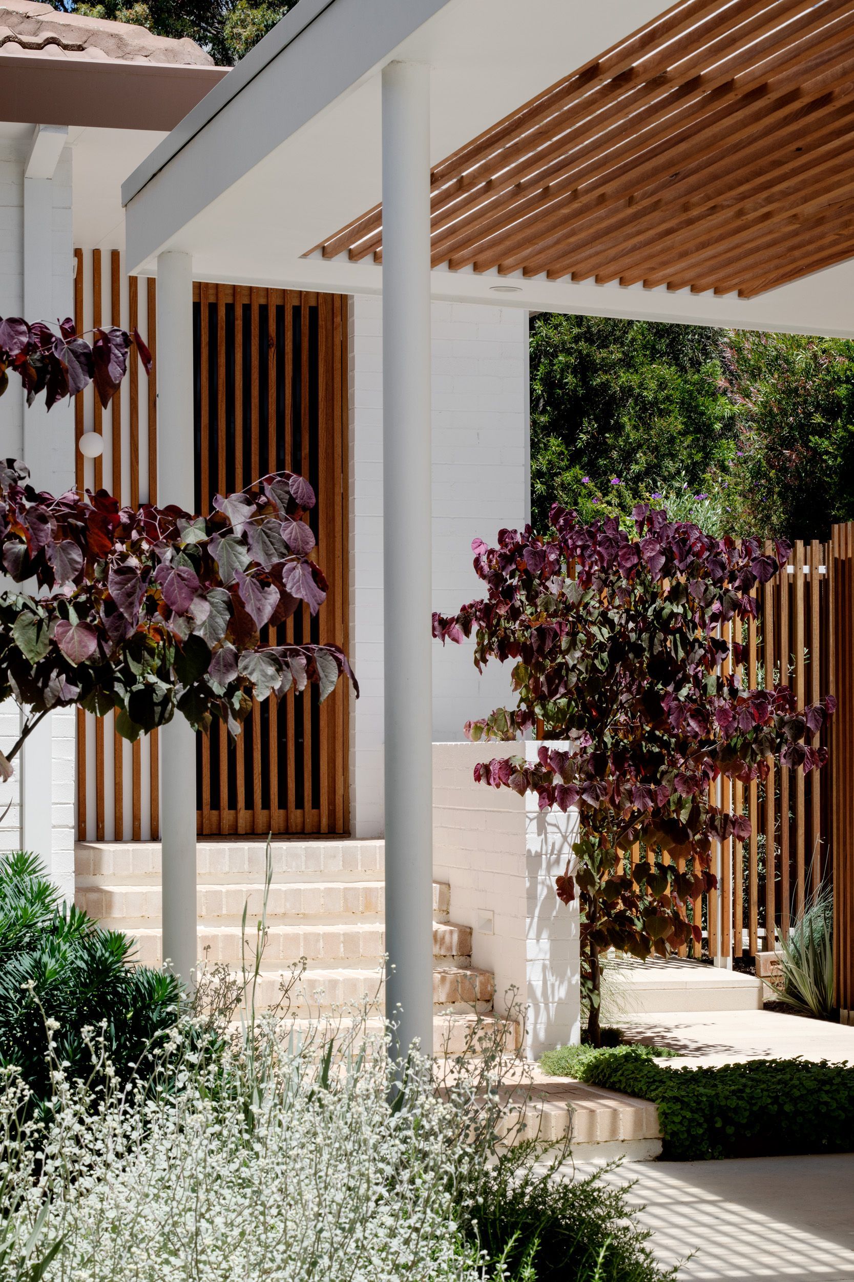 A white house with a wooden porch and stairs