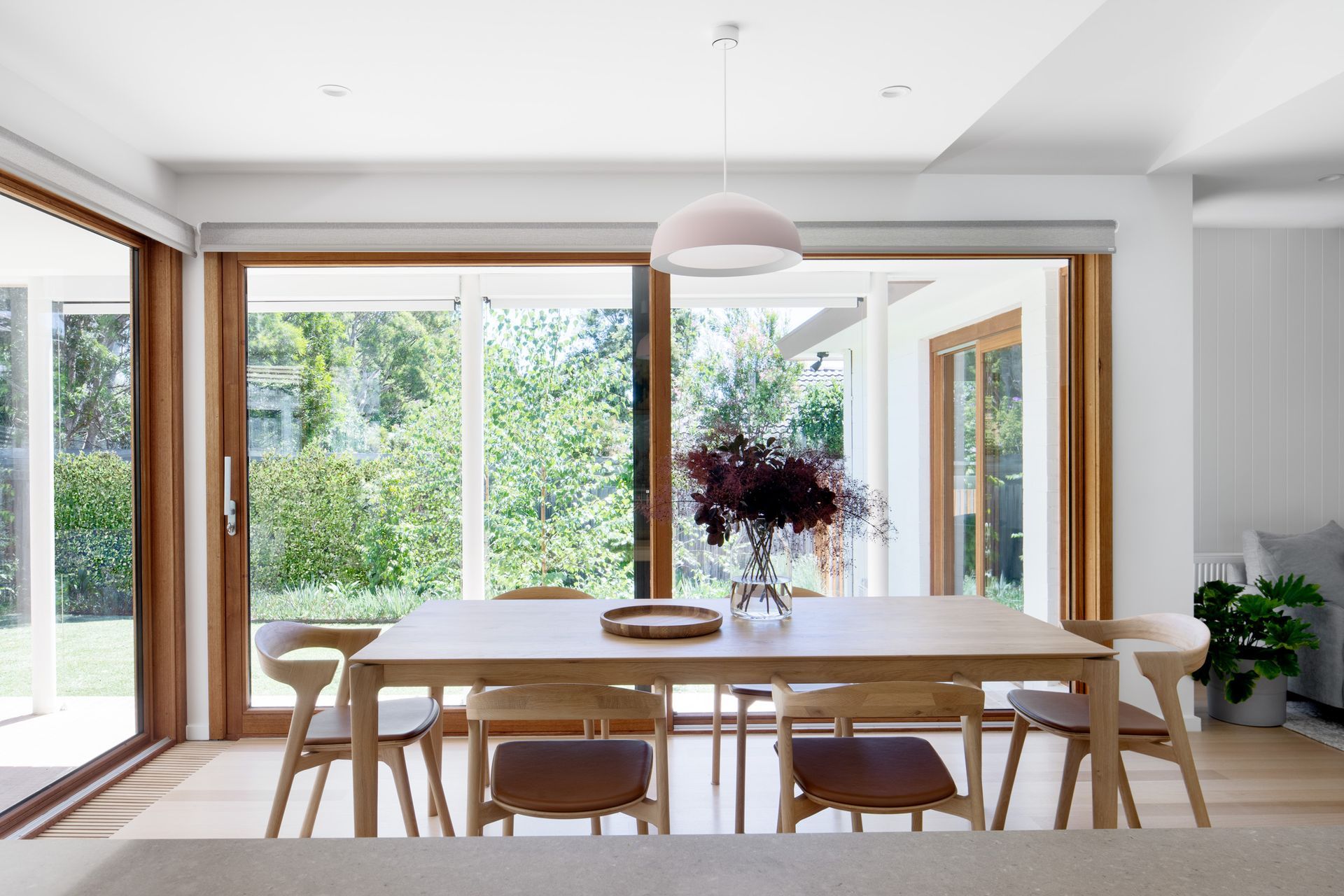 A dining room with a table and chairs and a large window.
