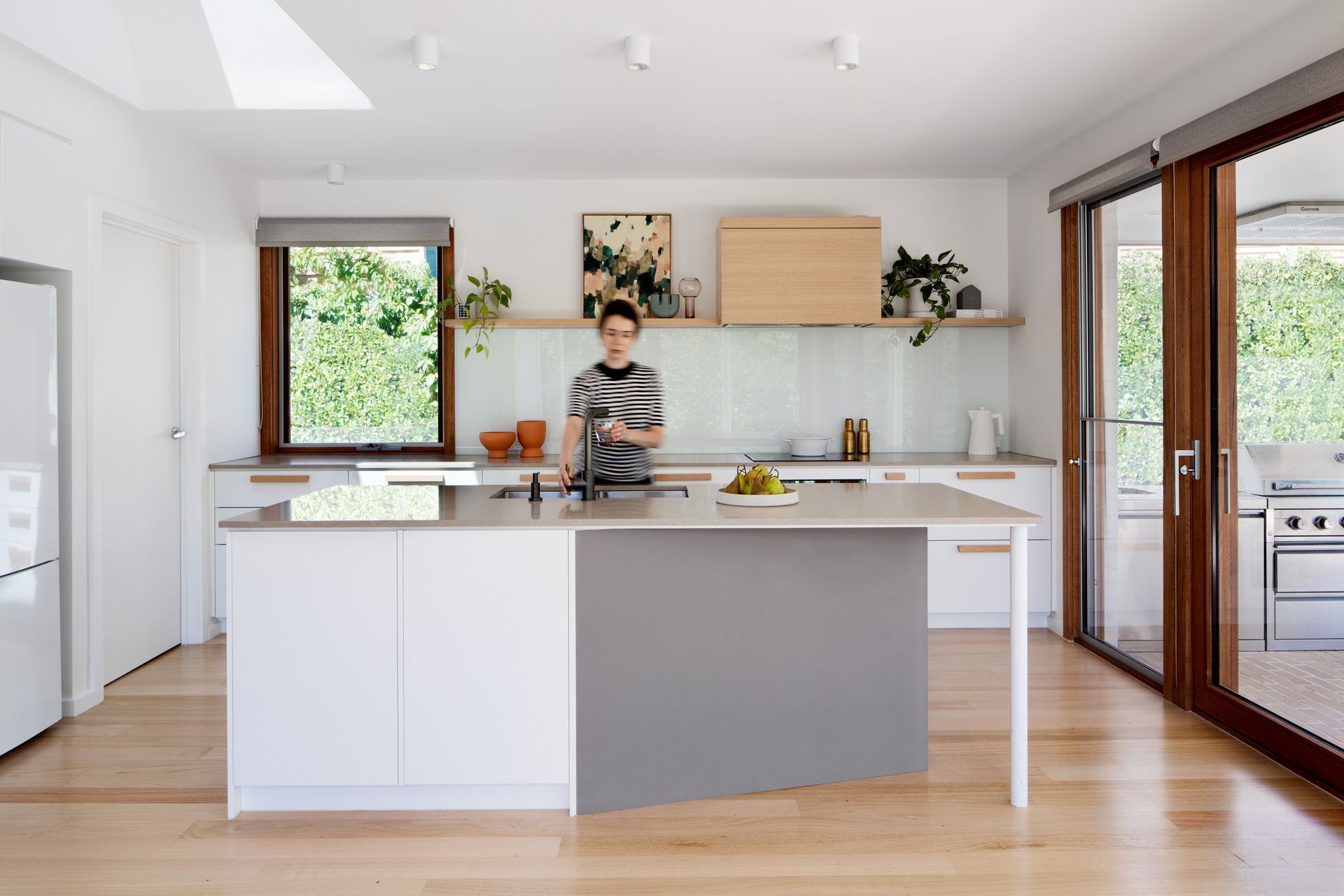 A woman is standing in a kitchen preparing food.