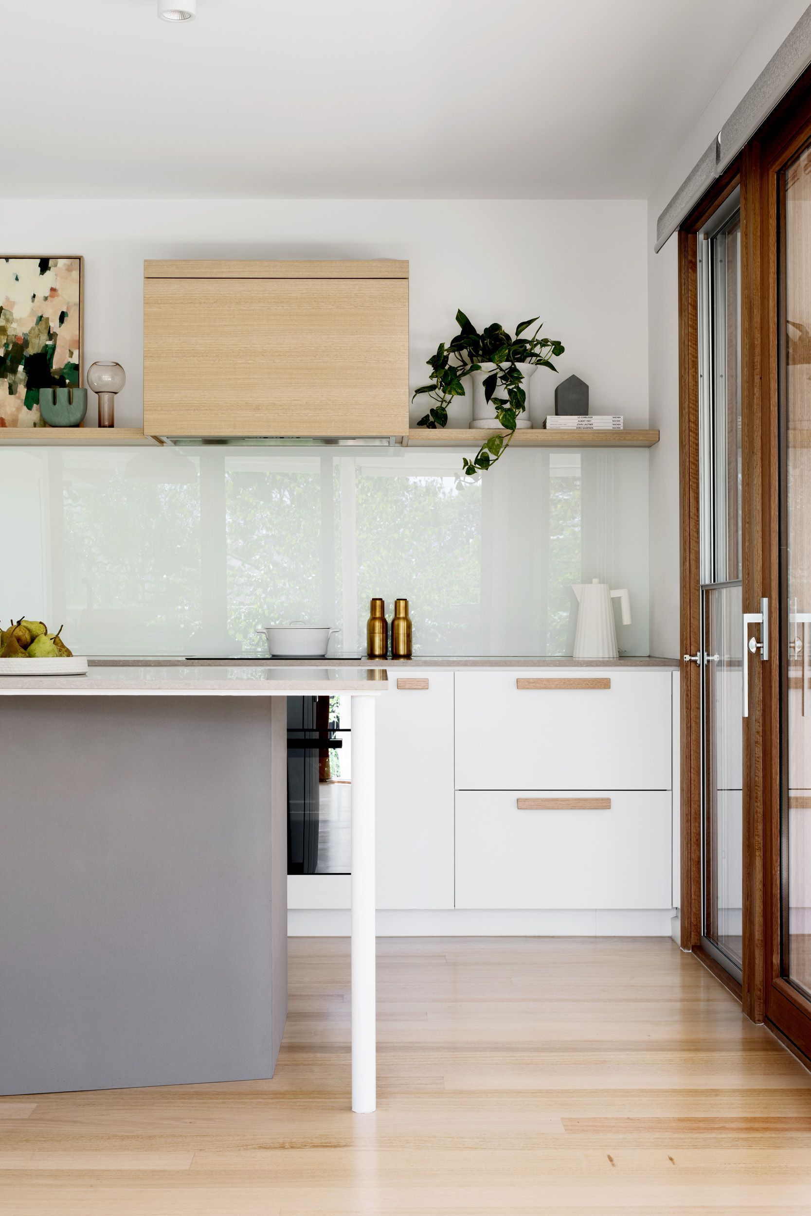 A kitchen with white cabinets and a gray island