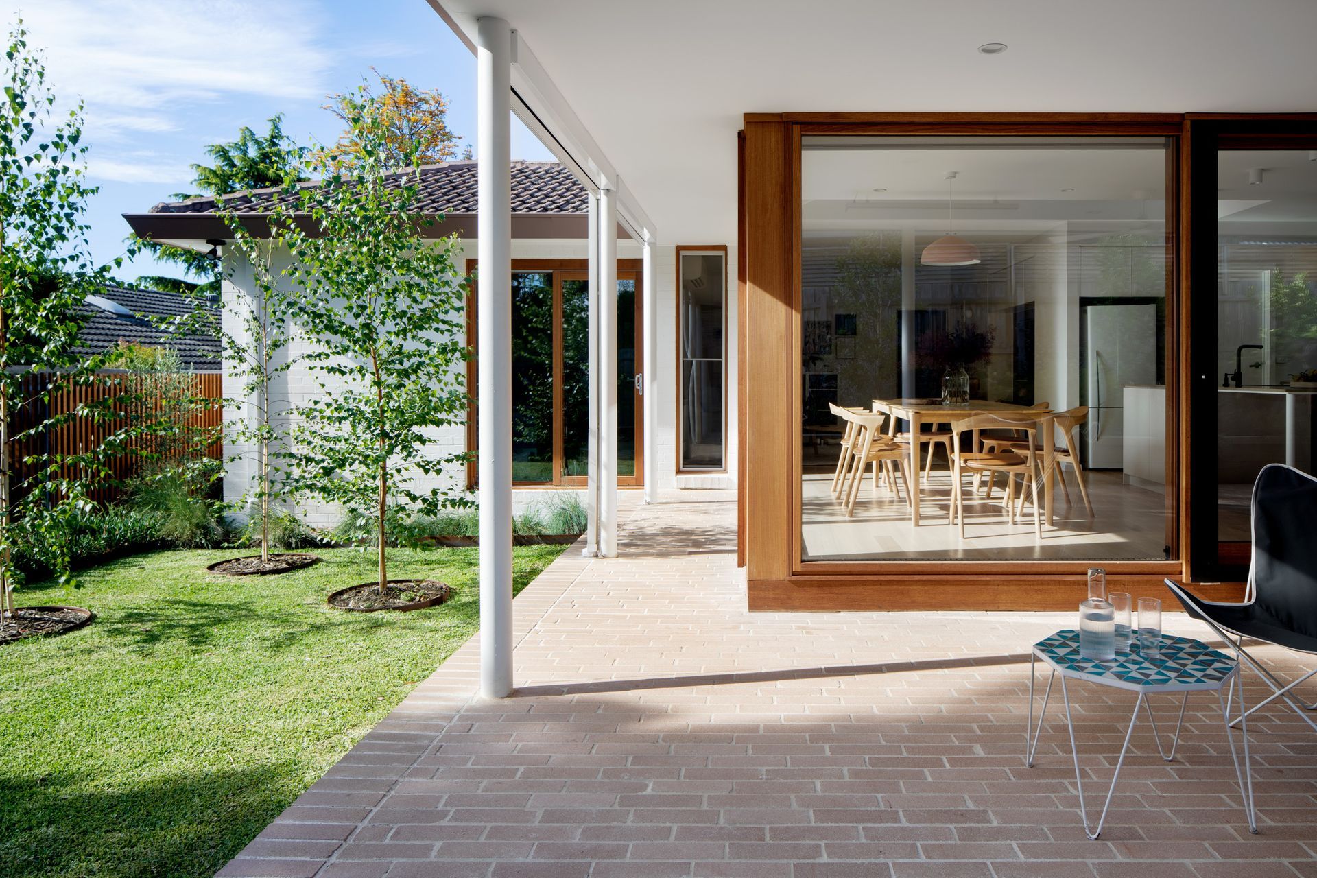 A patio with a table and chairs in front of a house.