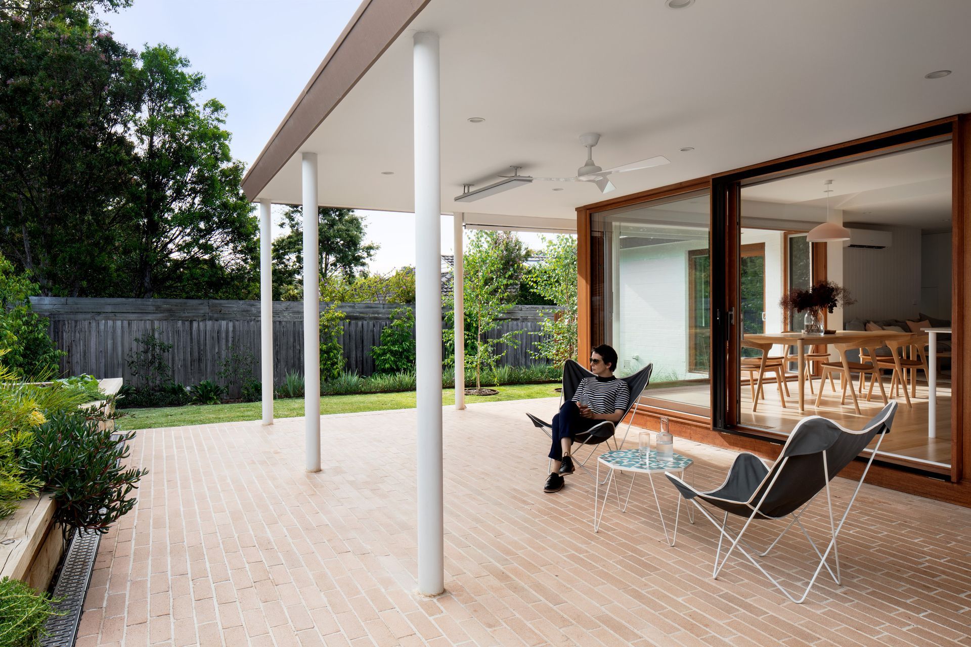 A person is sitting on a patio reading a book.