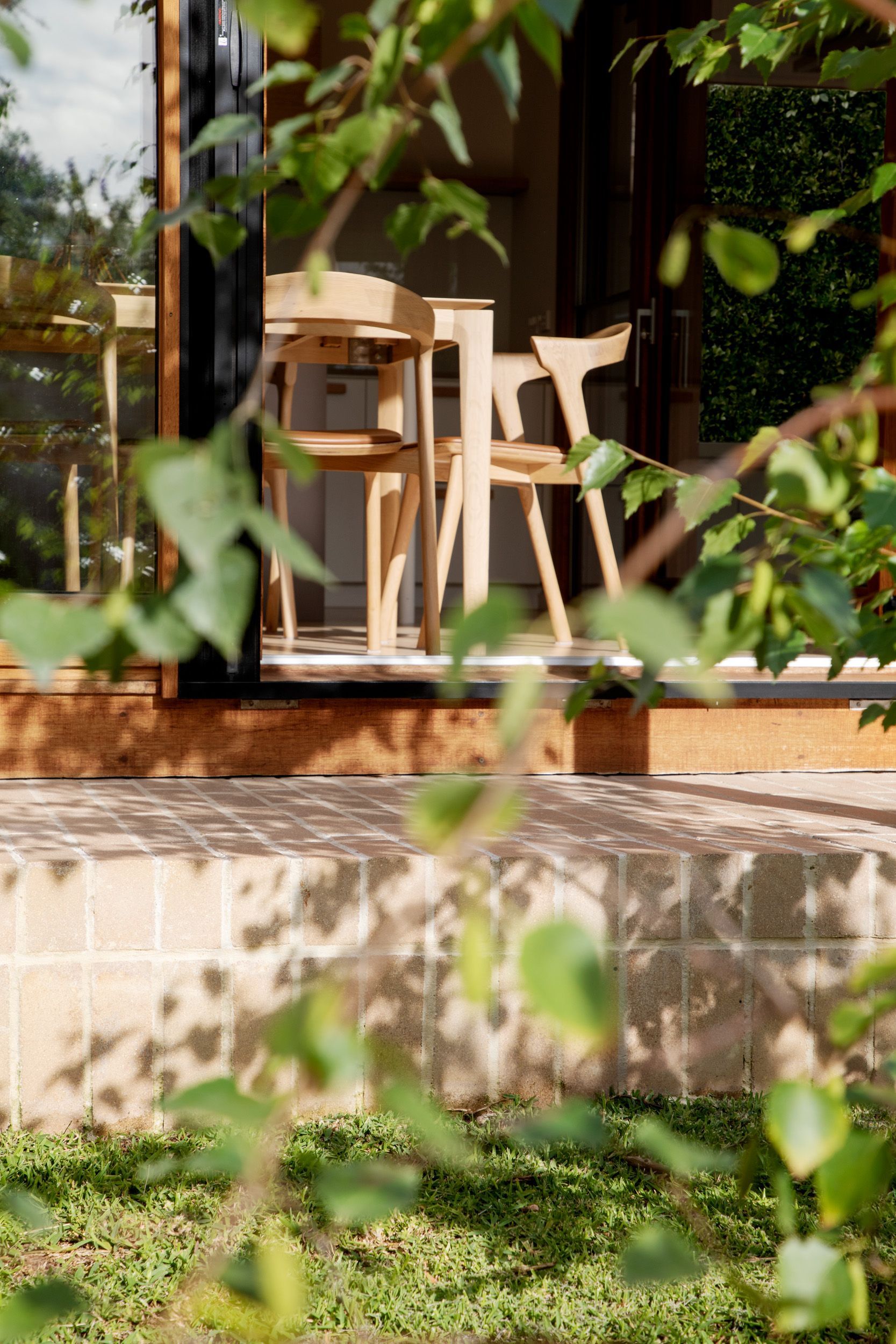 A table and chairs are sitting outside of a house.