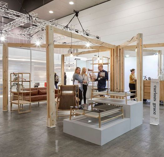 A group of people are standing in a room with a sign that says curtain store