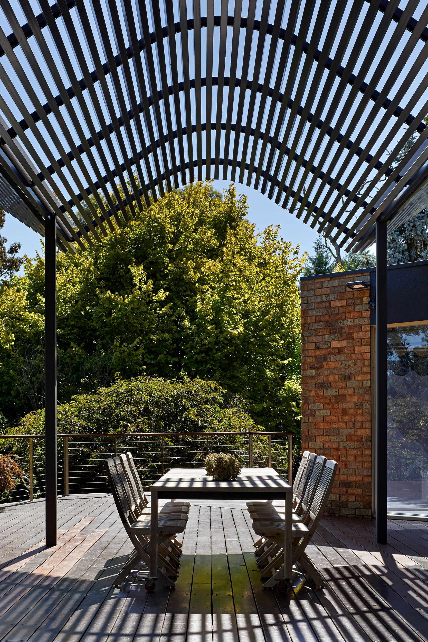 A patio with a table and chairs under a pergola.