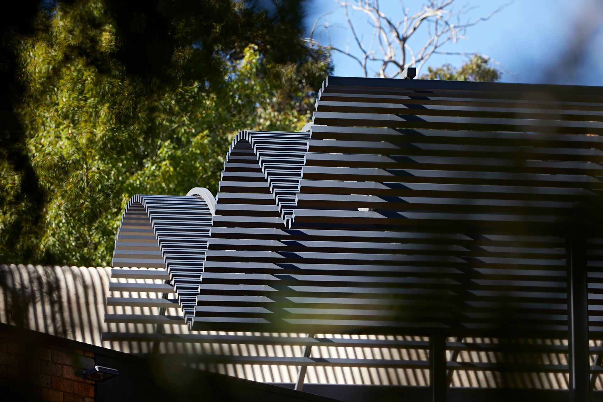 A close up of a roof of a building with trees in the background.