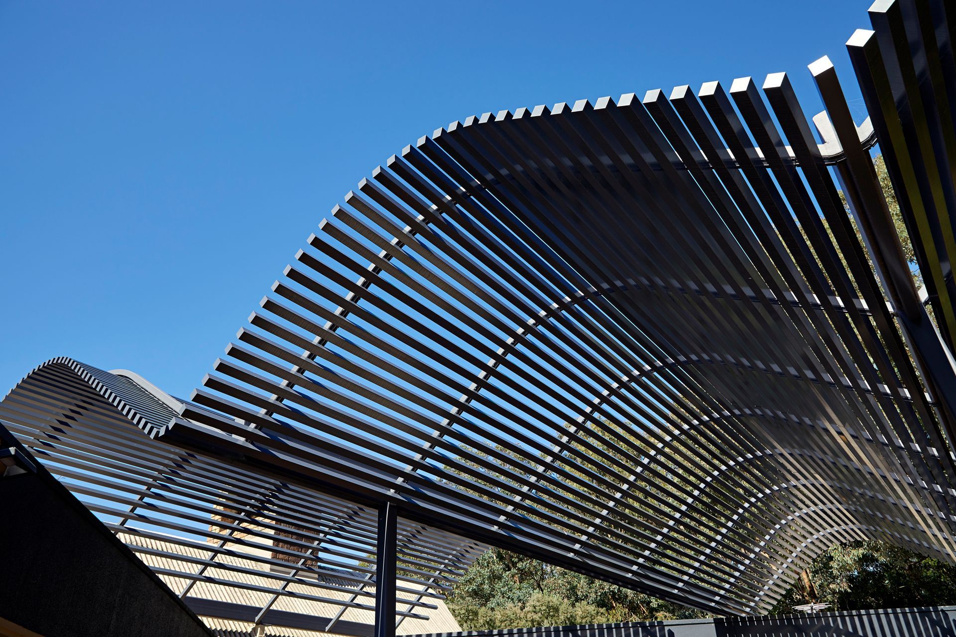 A curved metal structure with a blue sky in the background