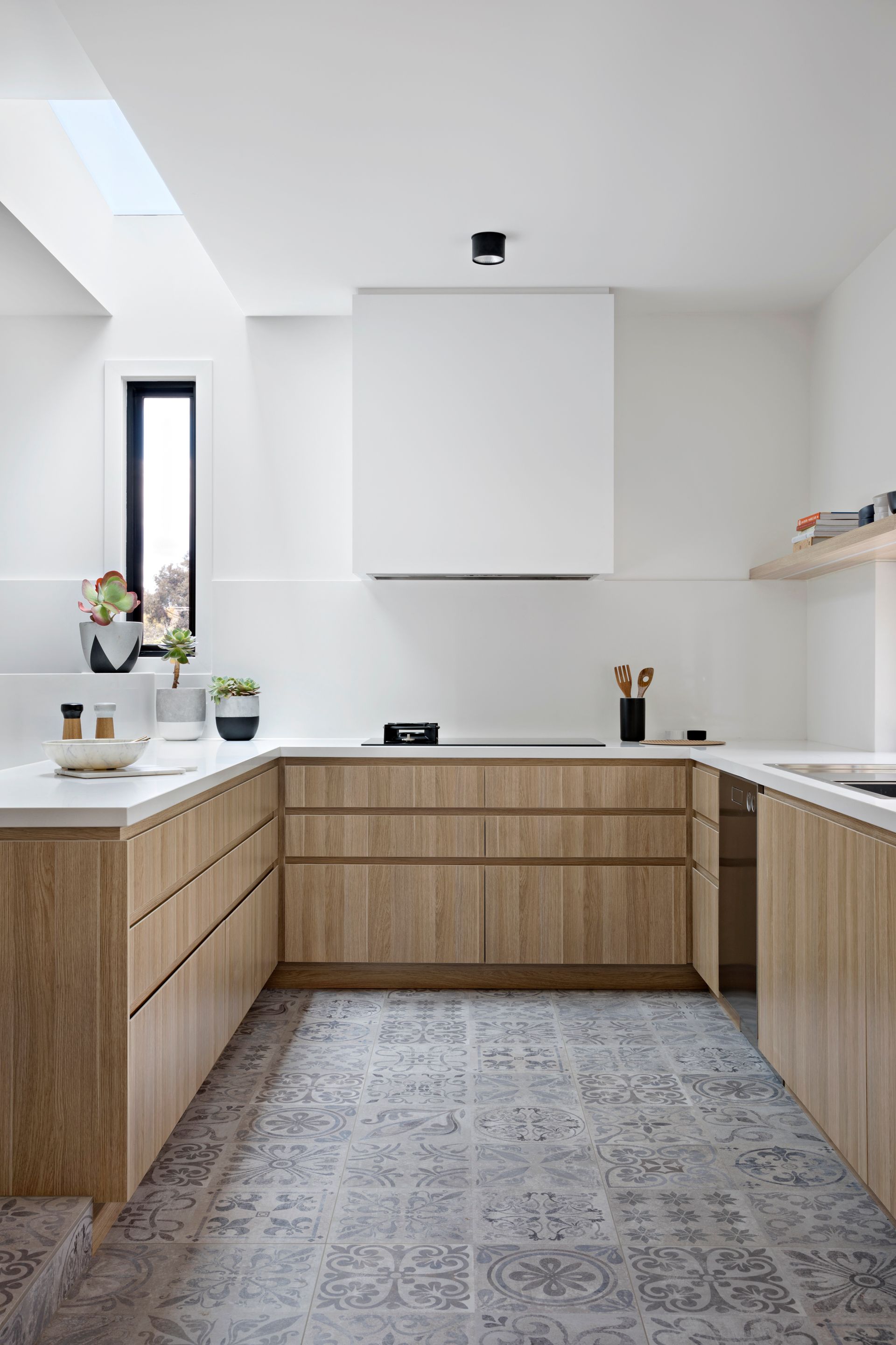 A kitchen with wooden cabinets and white counter tops.