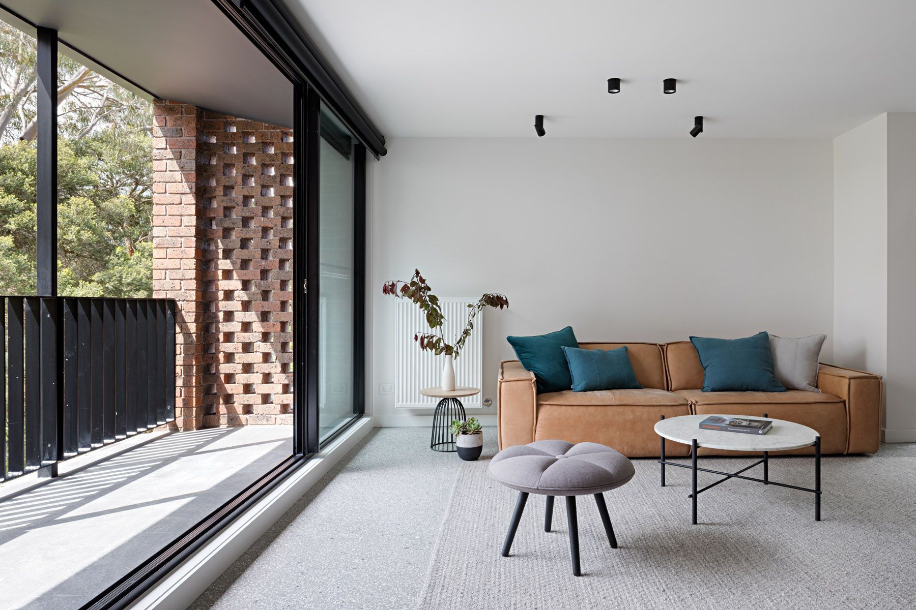 A living room with a couch , coffee table and balcony.
