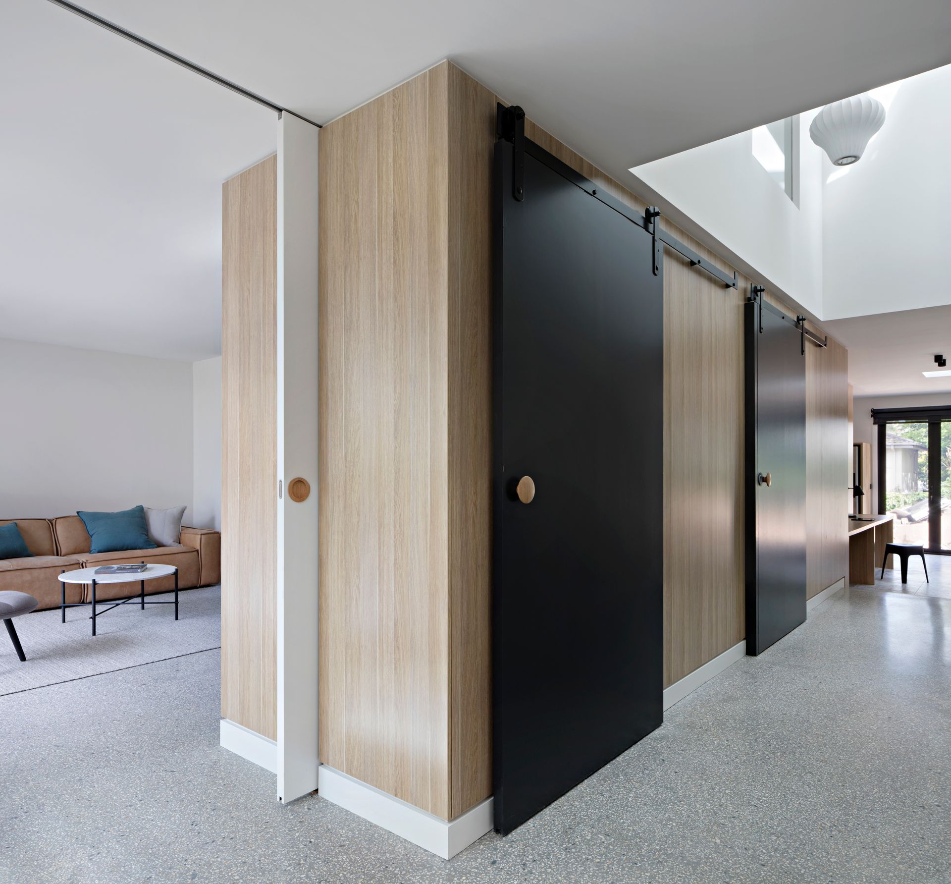 A hallway with a sliding barn door between two rooms