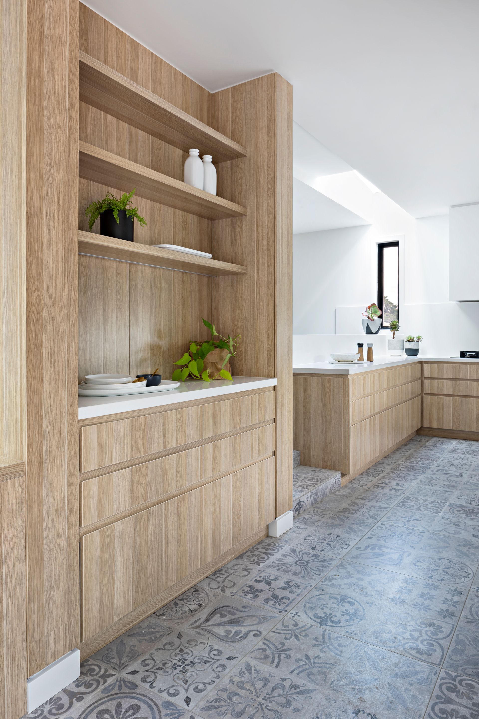A kitchen with wooden cabinets and a tiled floor.