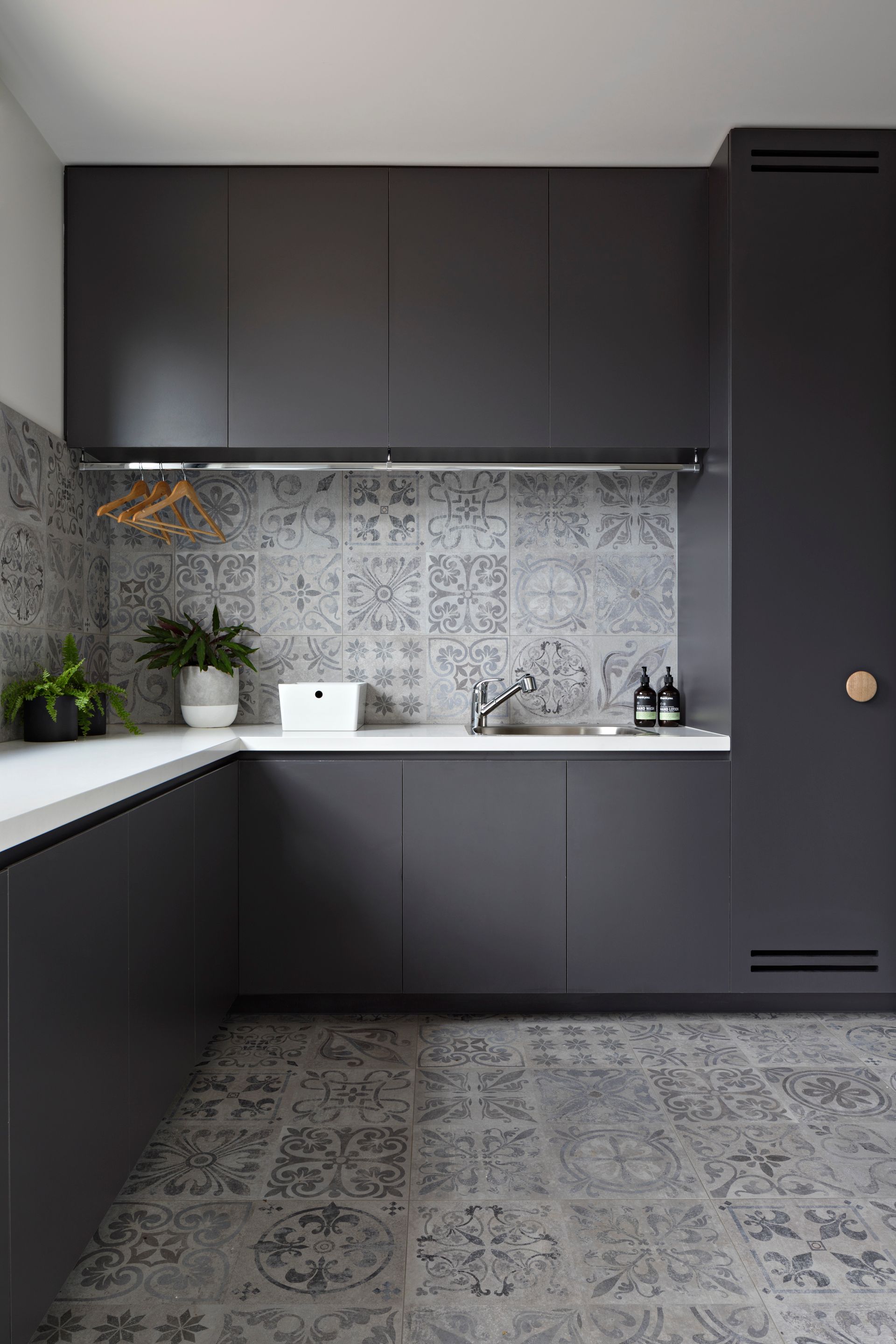 A kitchen with black cabinets and a white counter top.