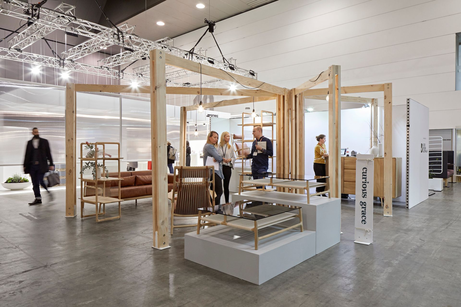 A group of people are standing in a room with a wooden structure.