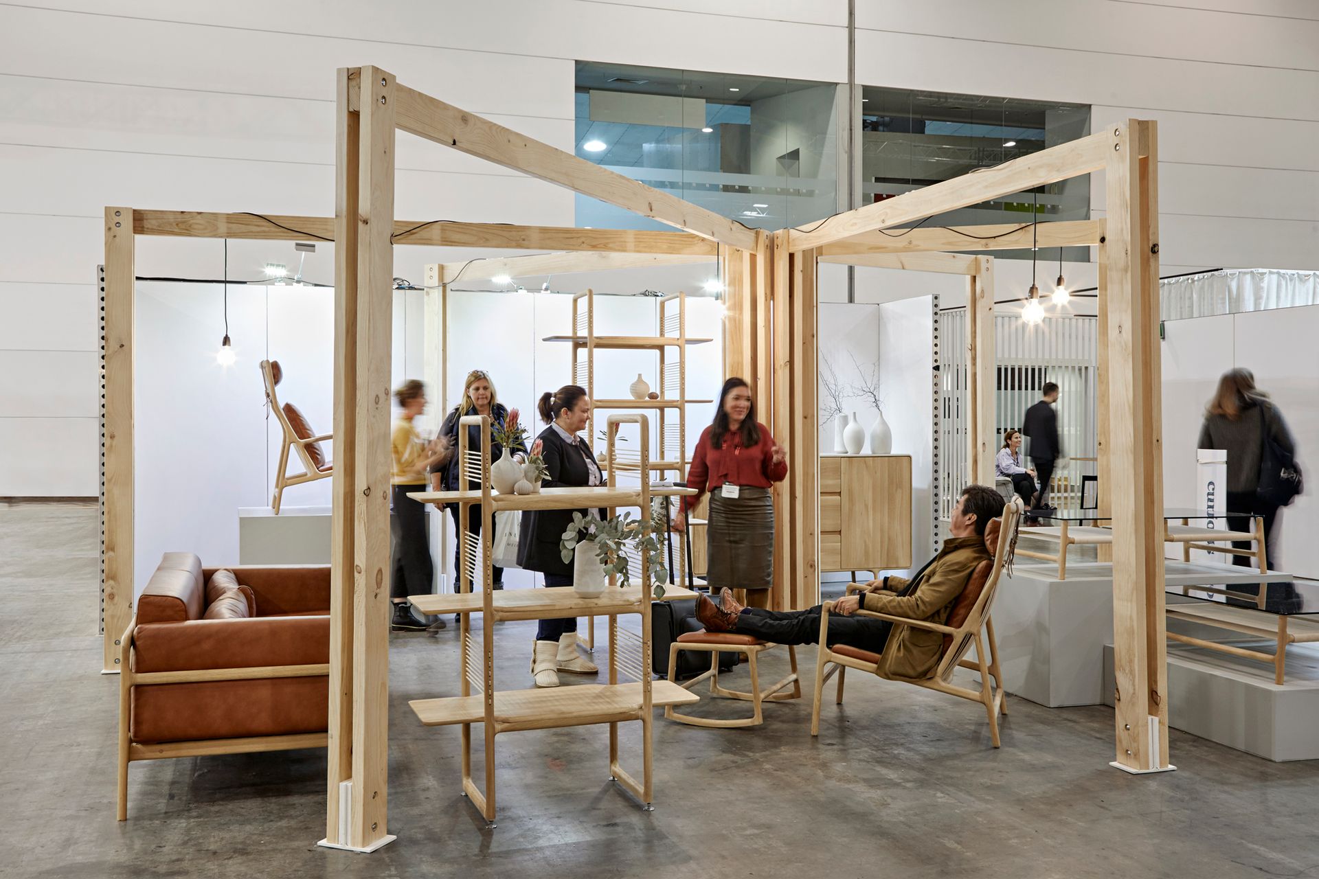 A group of people are standing in a room with wooden furniture.