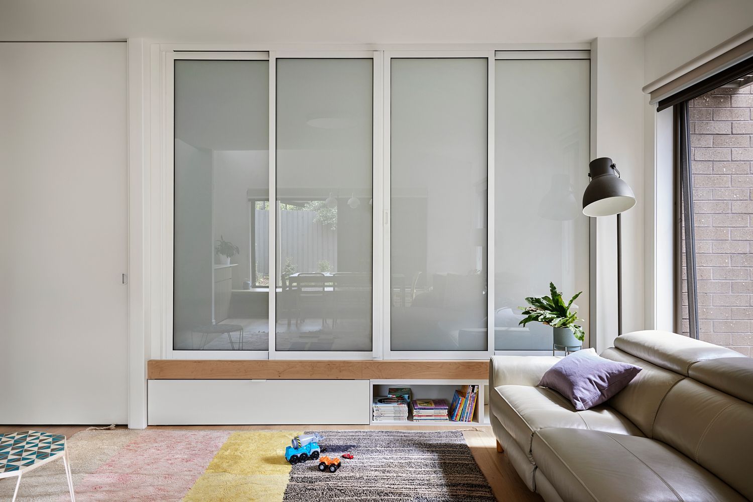 A living room with a couch and sliding glass doors.