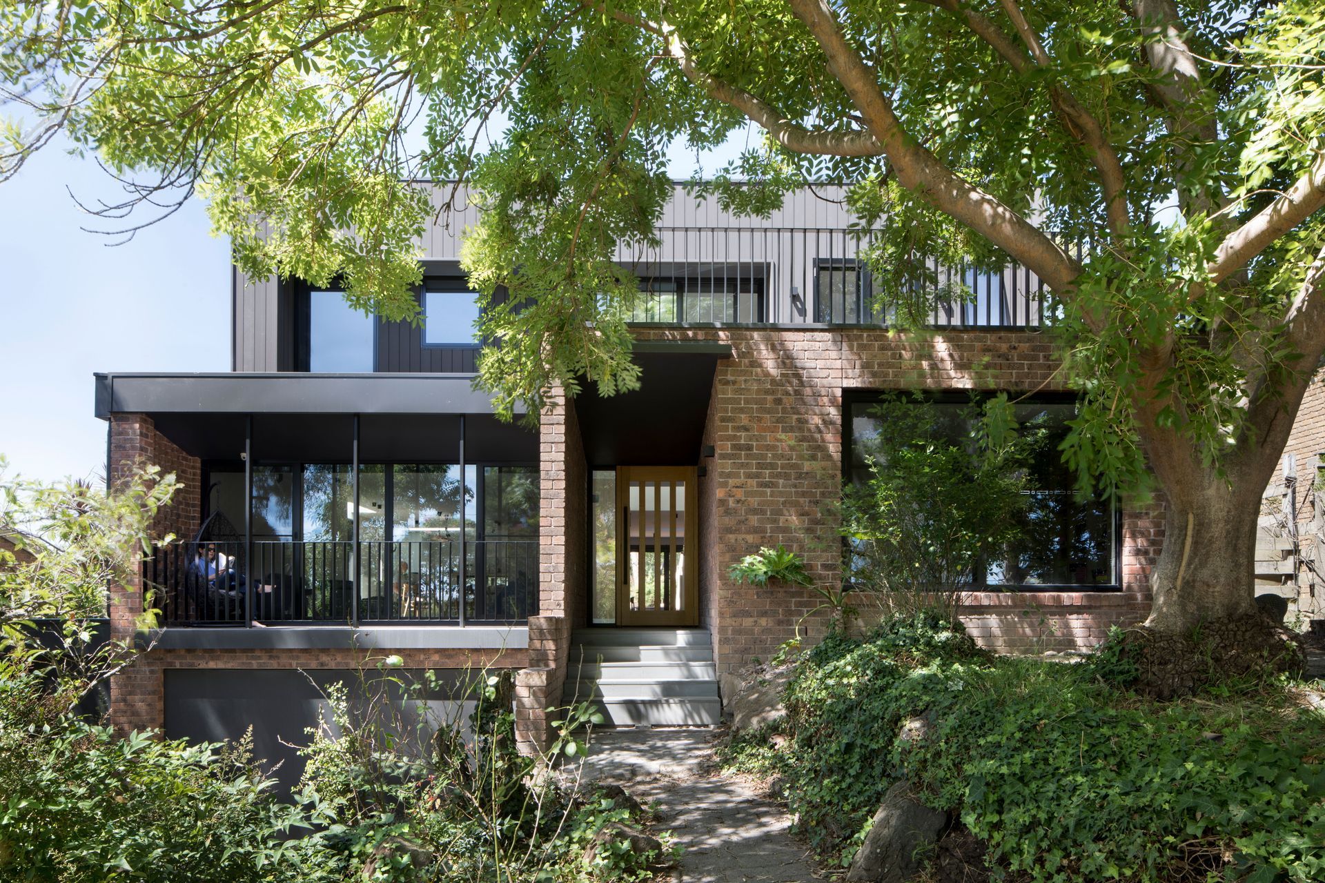 A large brick house with a large tree in front of it.