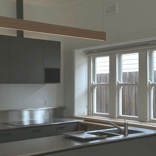 A kitchen with stainless steel cabinets , a sink , and a window.