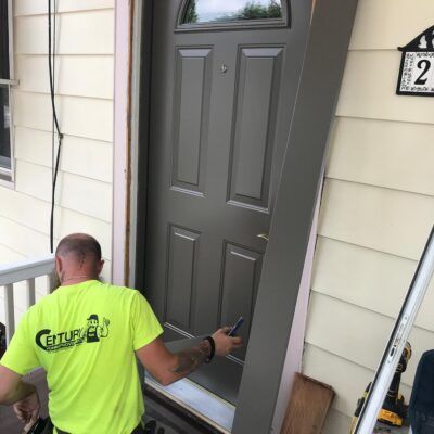 Door frame is being adjusted, and the setting is a residential exterior.