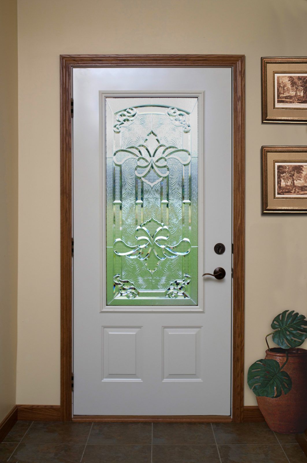 White front door with decorative glass panel and dark wood trim. The door has a knob and is set in a beige wall.
