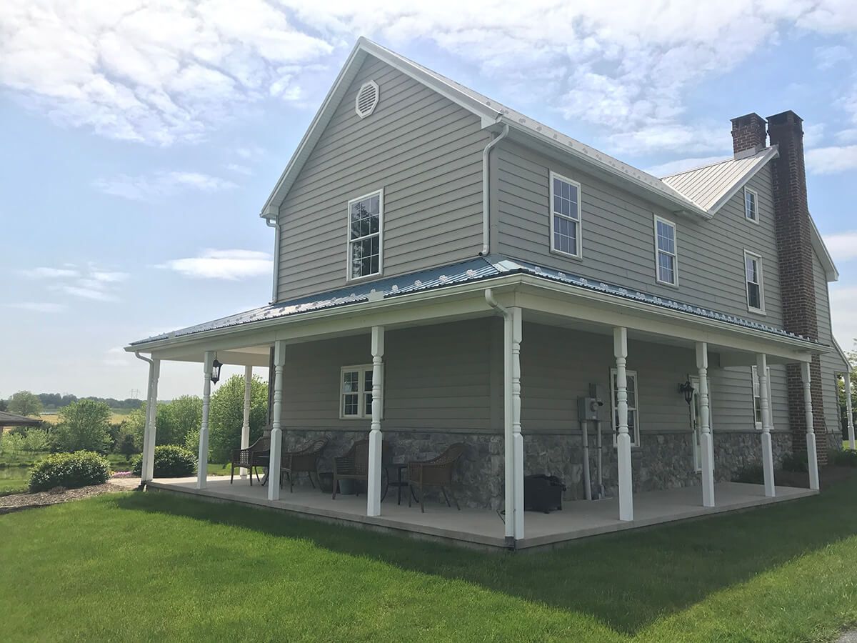 A roof with a green gutter and trees in the background