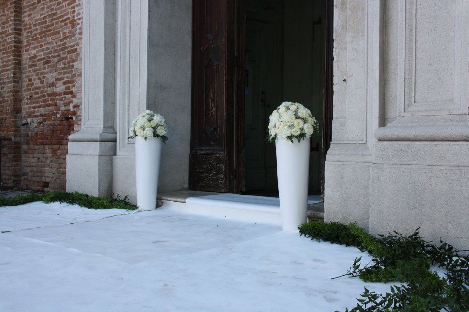Entrata di una chiesa decorata con fiori bianchi