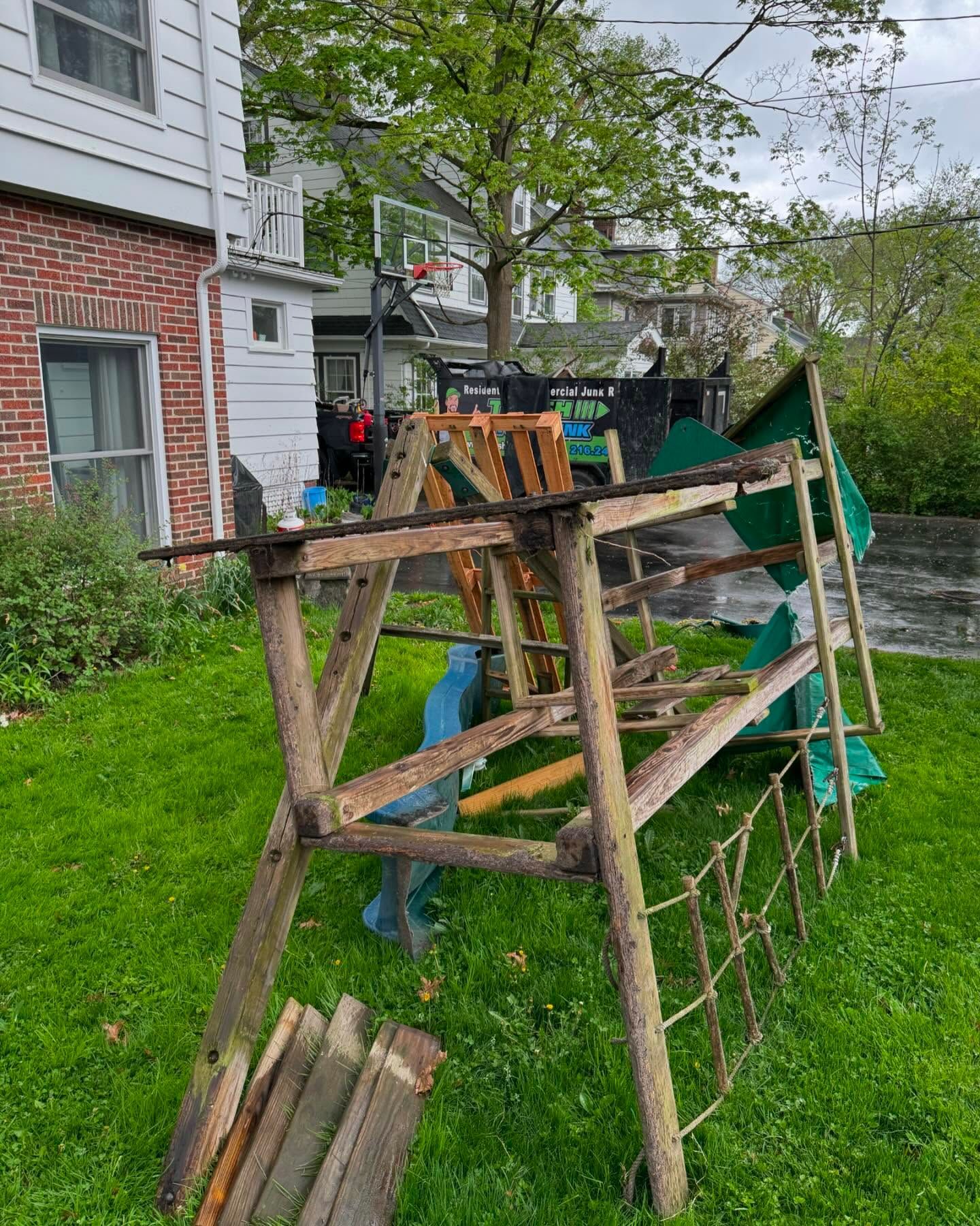A wooden ladder is sitting in the grass in front of a house.