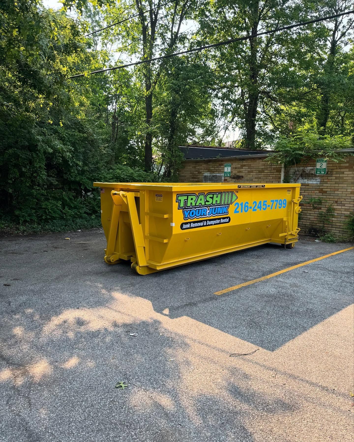 A trash your junk trailer is parked next to a van