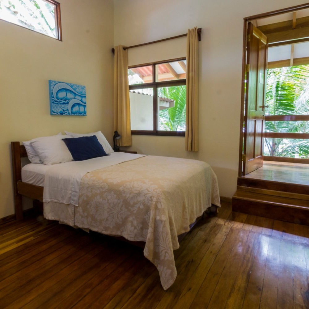 A bedroom with a bed and a painting on the wall