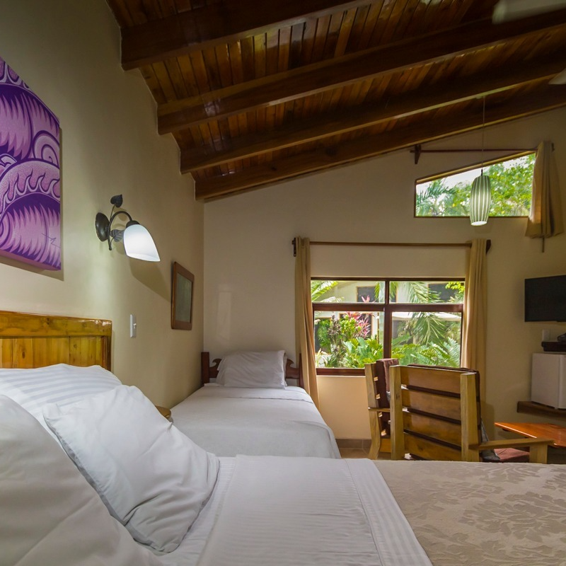 A hotel room with two beds and a large window