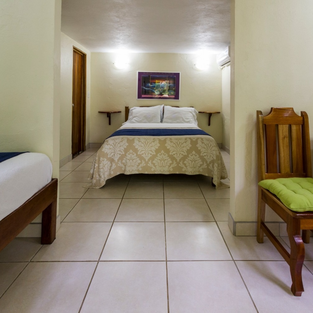 A hotel room with two beds and a chair