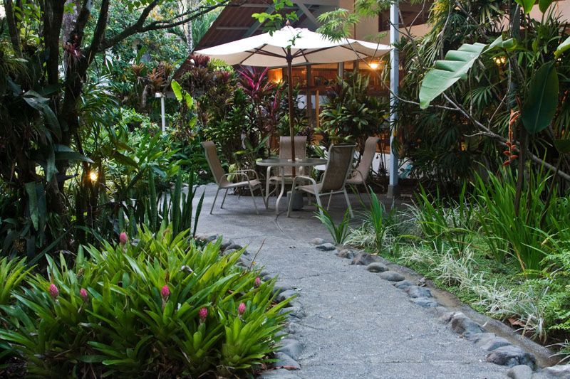 A garden with a table and chairs under an umbrella
