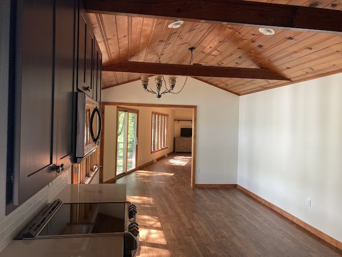 A kitchen with a wooden ceiling and a stove top oven