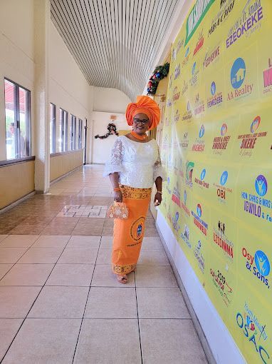 A woman is standing in a hallway next to a yellow wall.