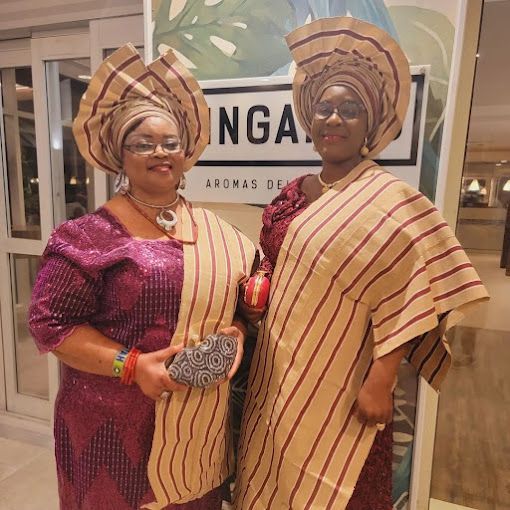 Two women in traditional african clothing are standing next to each other.