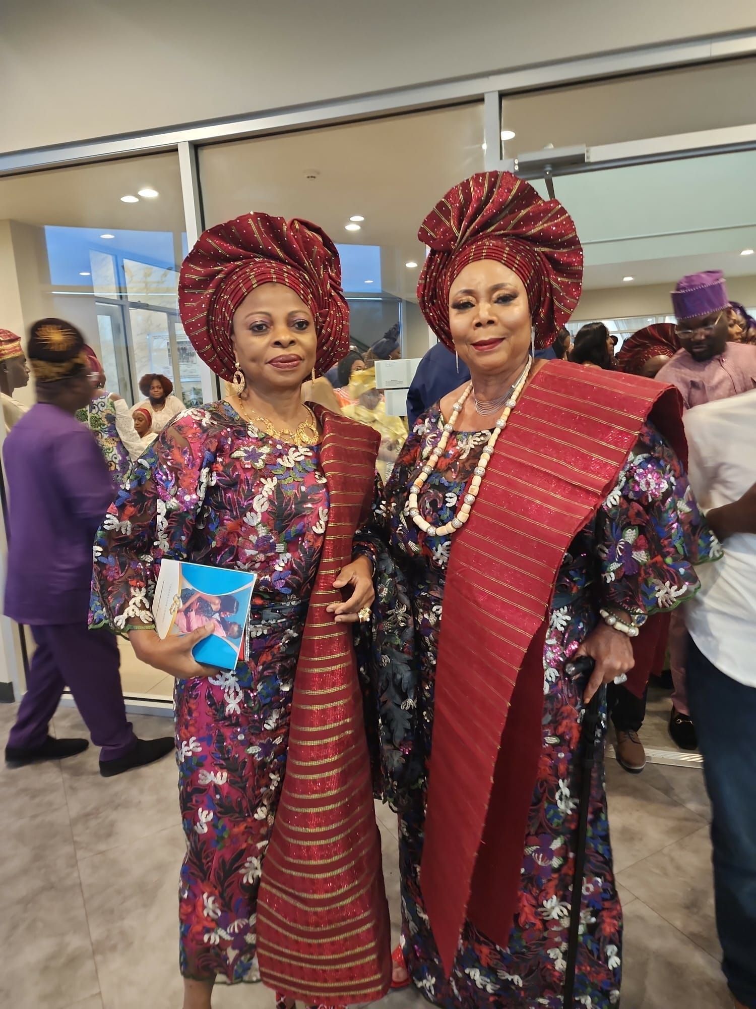 Two women in traditional clothes are standing next to each other in a room.