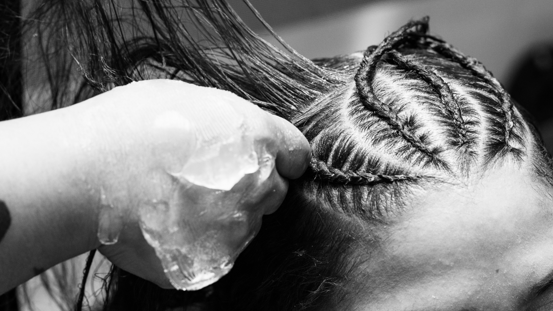 A person is holding an ice cube in their hair.