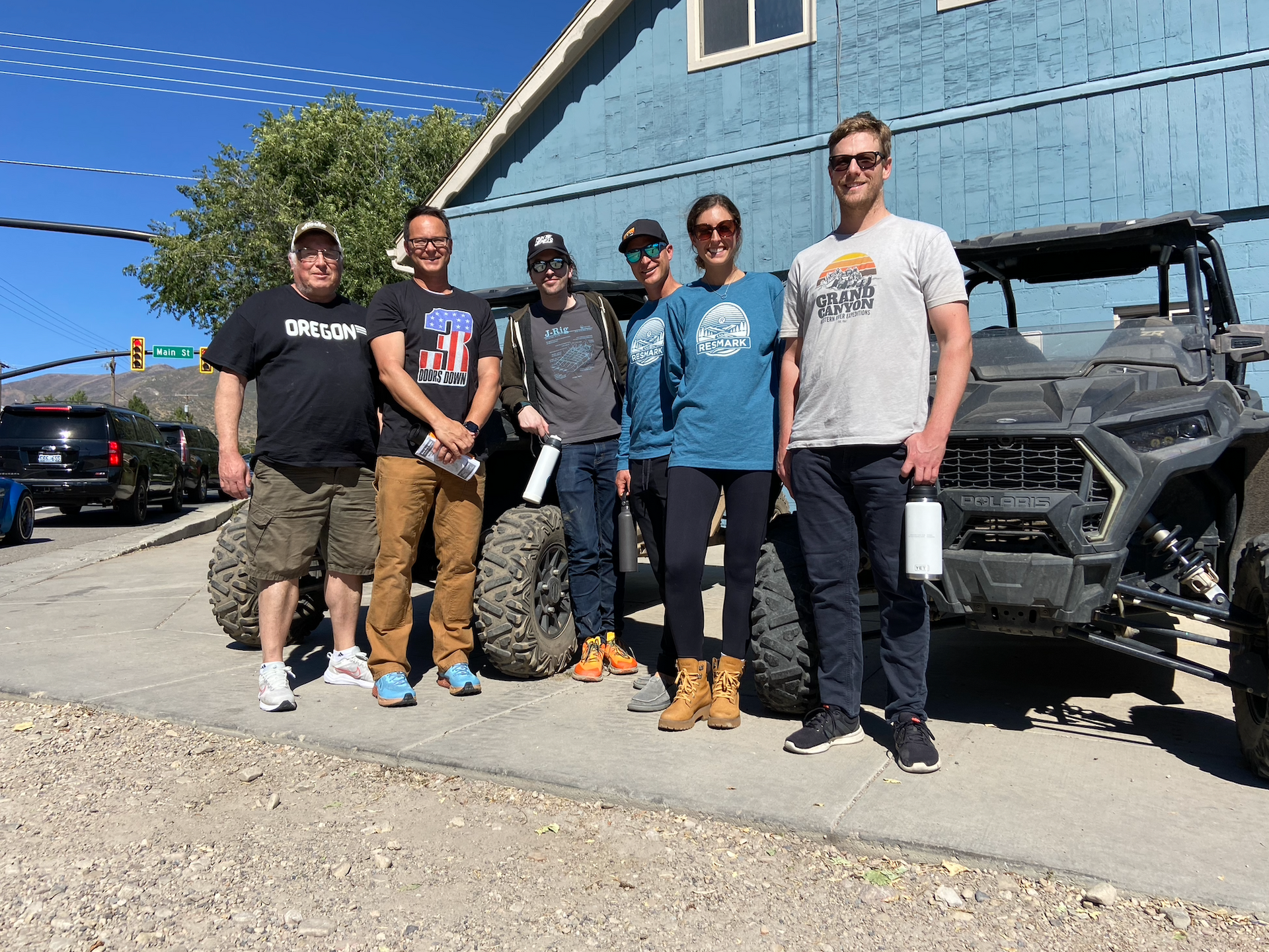 6 people in front of four by four outside of a blue building