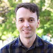 A man in a plaid shirt is smiling for the camera.