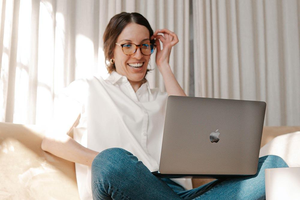 Woman on couch using laptop